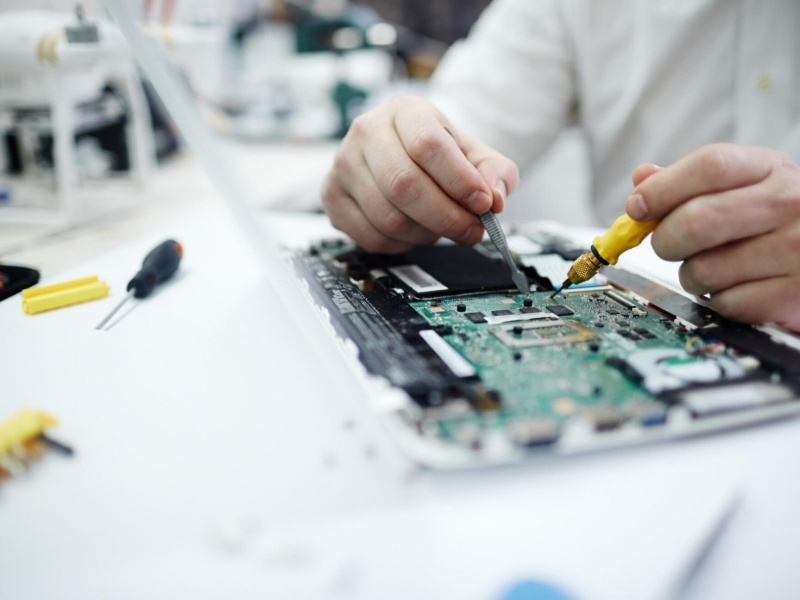 man repairing circuit board in laptop scaled